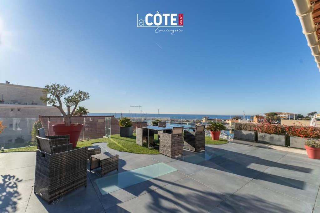 un patio avec des chaises et des tables sur un toit dans l'établissement Terrasse vue mer - 8 Couchages, à Sausset-les-Pins