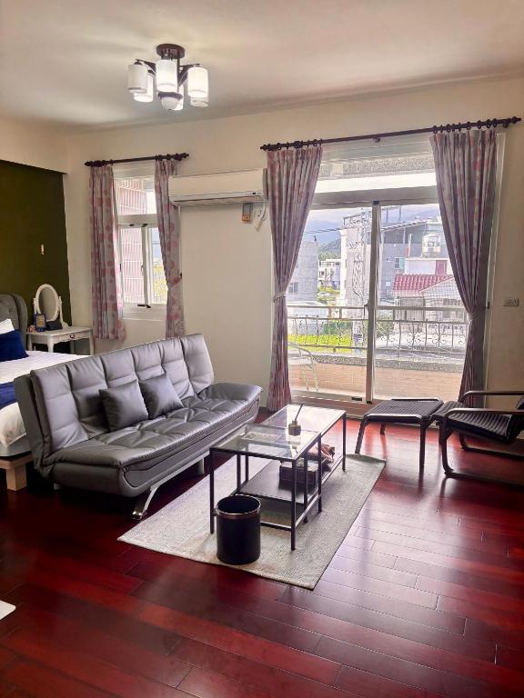 a living room with a couch and a large window at 伊家民宿Yi home 志航路一段398號 in Taitung City