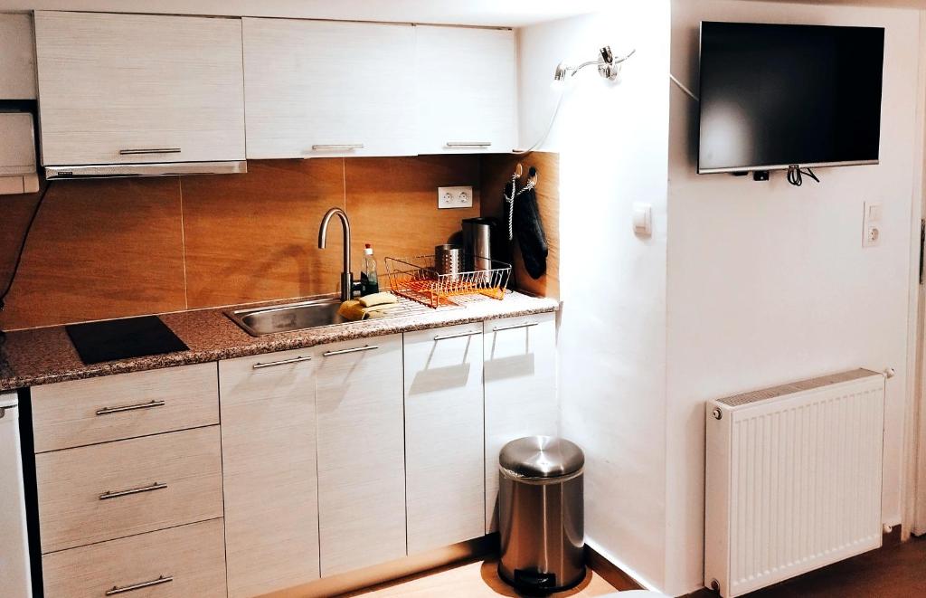 eine Küche mit weißen Schränken und einem Waschbecken in der Unterkunft Beautiful cozy apartment in Athen