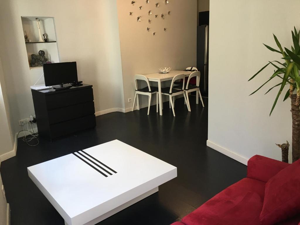 a living room with a red couch and a table at Coeur Vieil Antibes Plages à Pied in Antibes