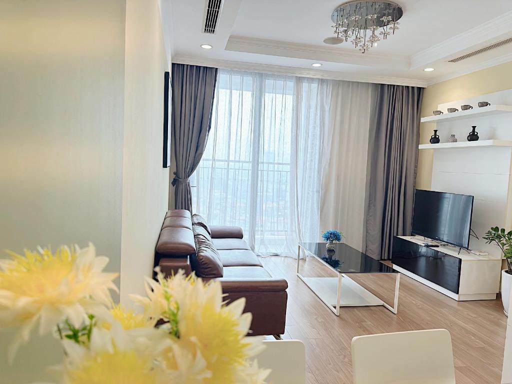 sala de estar con sofá y TV en Vinhomes Times City 1BR, en Hanói