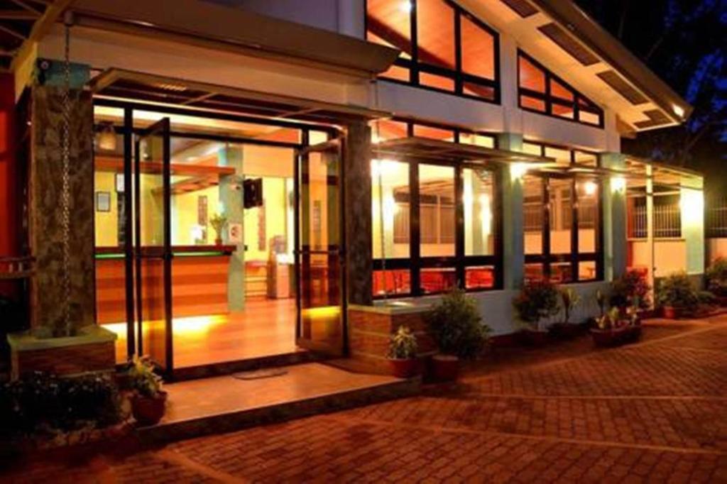 un bâtiment avec une porte ouverte la nuit dans l'établissement Julieta's Pension House, à Puerto Princesa