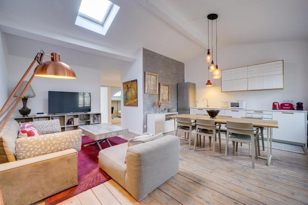 un salon avec une table et une salle à manger dans l'établissement Le Particulier - Centre ville de Bordeaux, à Bordeaux