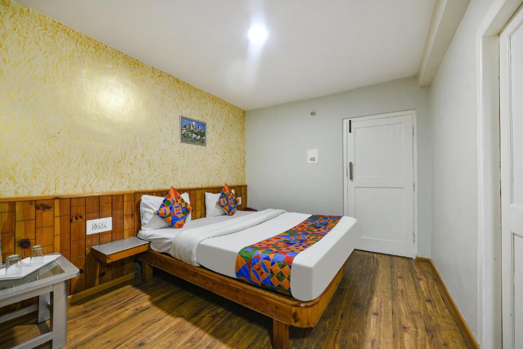 a bedroom with a bed and a table and a window at FabHotel Monalisa in Manāli