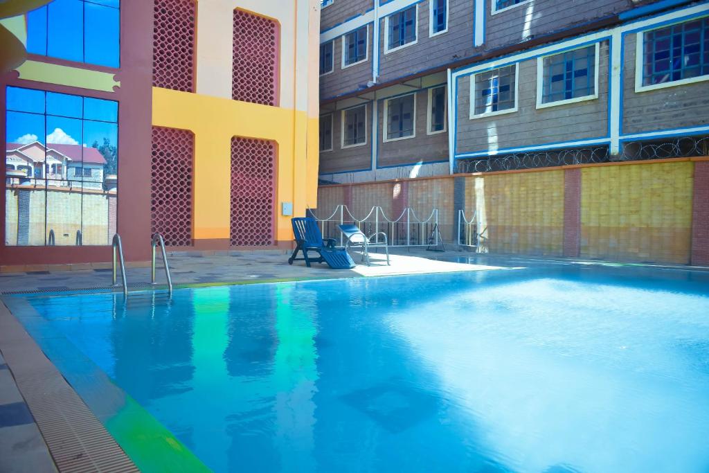 a large swimming pool in front of a building at Balozi Luxury Homes in Nanyuki