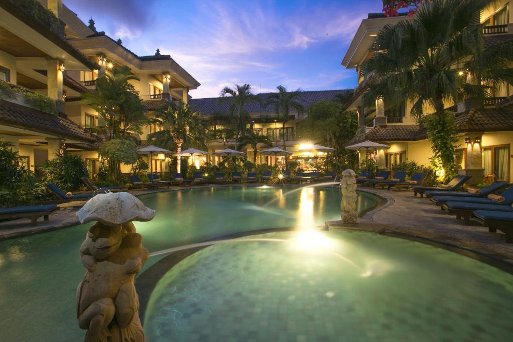 a pool at a resort with a bear statue in the middle at Parigata Resorts and Spa in Sanur