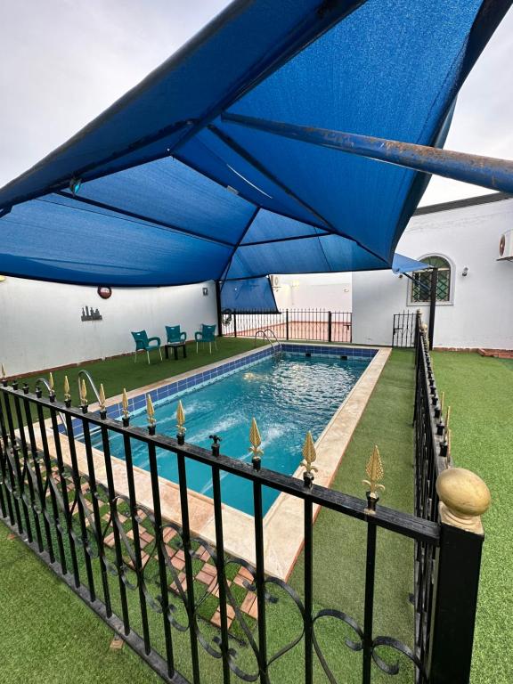 um grande guarda-chuva azul sobre uma piscina em استراحة رفييف em Khalij Salman