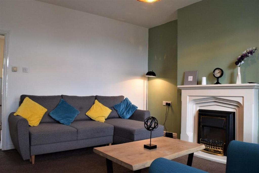 a living room with a couch and a fireplace at Glossop Retreat 1 King2 Dbl Cottage in Glossop