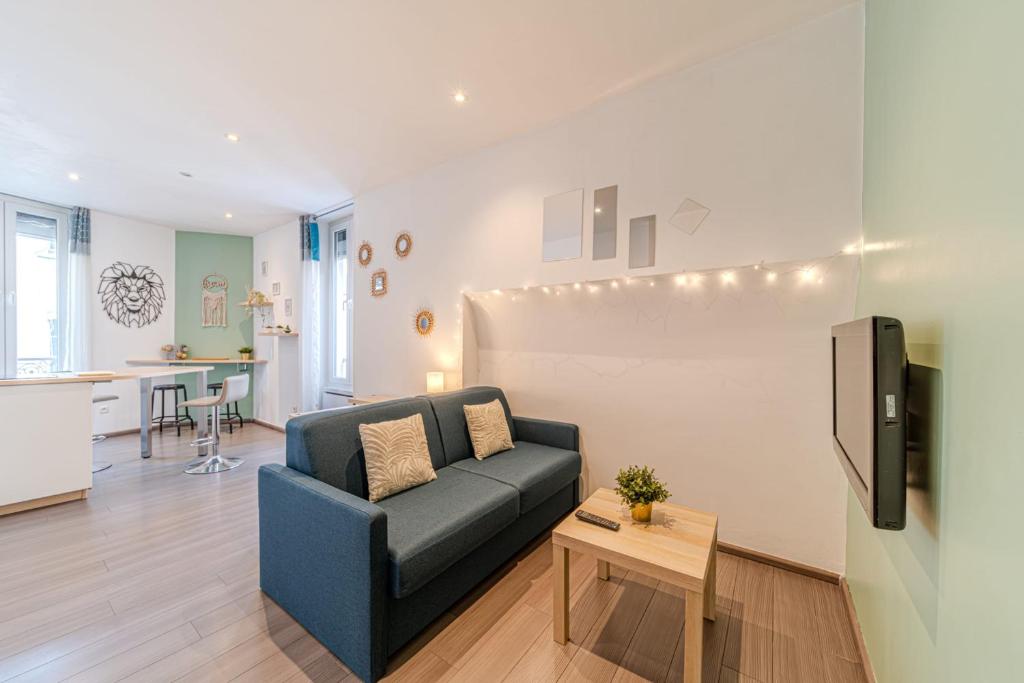 un salon avec un canapé bleu et une table dans l'établissement Le St Antoine cosy 4 pers Lafayette Part Dieu, à Lyon