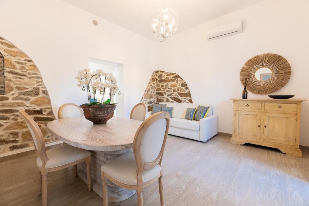 a dining room with a table and chairs and a couch at Stazzo San Teodoro in San Teodoro