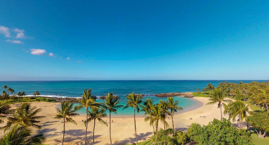 an aerial view of a beach with palm trees and the ocean at Ko Olina Beach Villas B609 in Kapolei