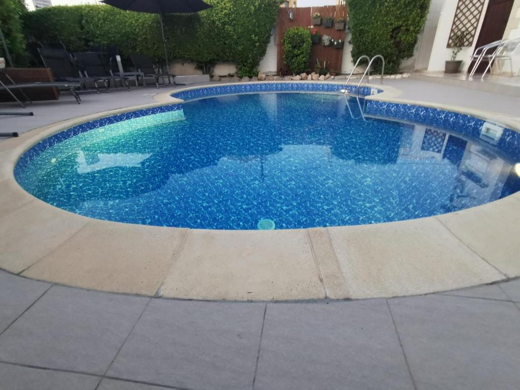 una gran piscina con agua azul en un patio en The Serenity Bungalow en Anarita