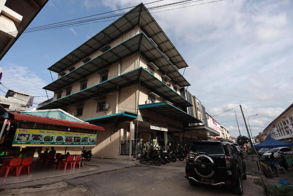 une petite voiture garée devant un bâtiment dans l'établissement OYO 93671 Sir Homestay, à Nagoya