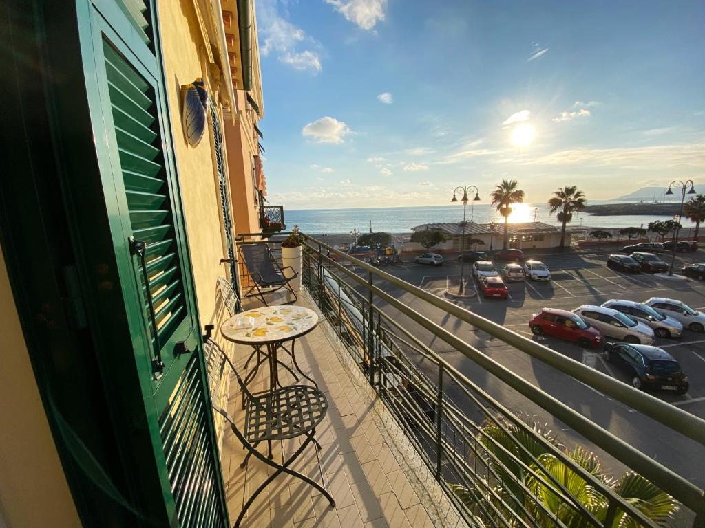 a balcony with a table and a view of a parking lot at L'ETERNITA' E' IL MARE MISCHIATO COL SOLE Rimbaud in Ventimiglia