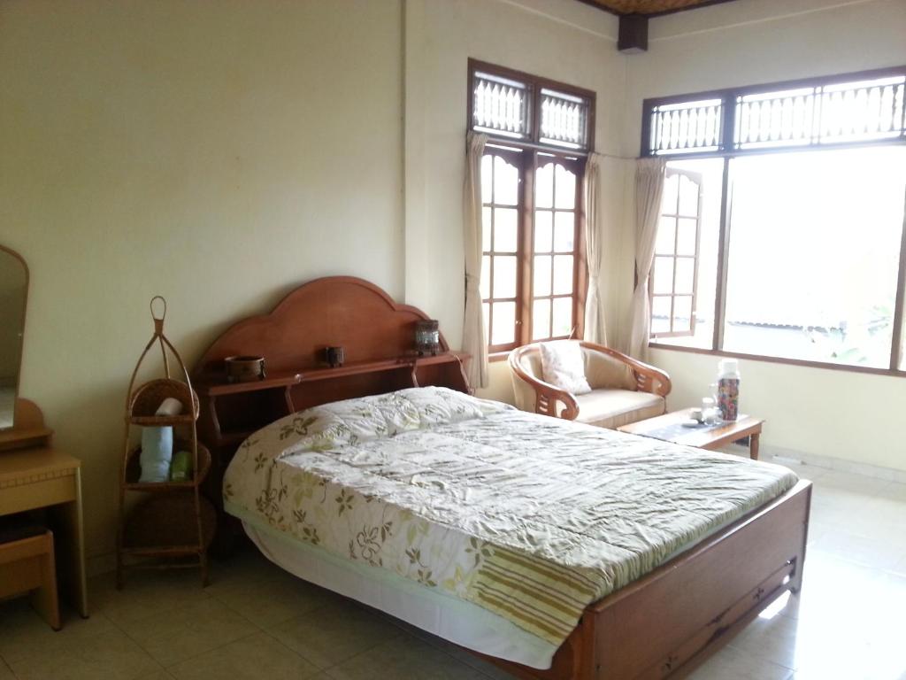 
a bedroom with a bed and a window at Runa Guesthouse in Ubud
