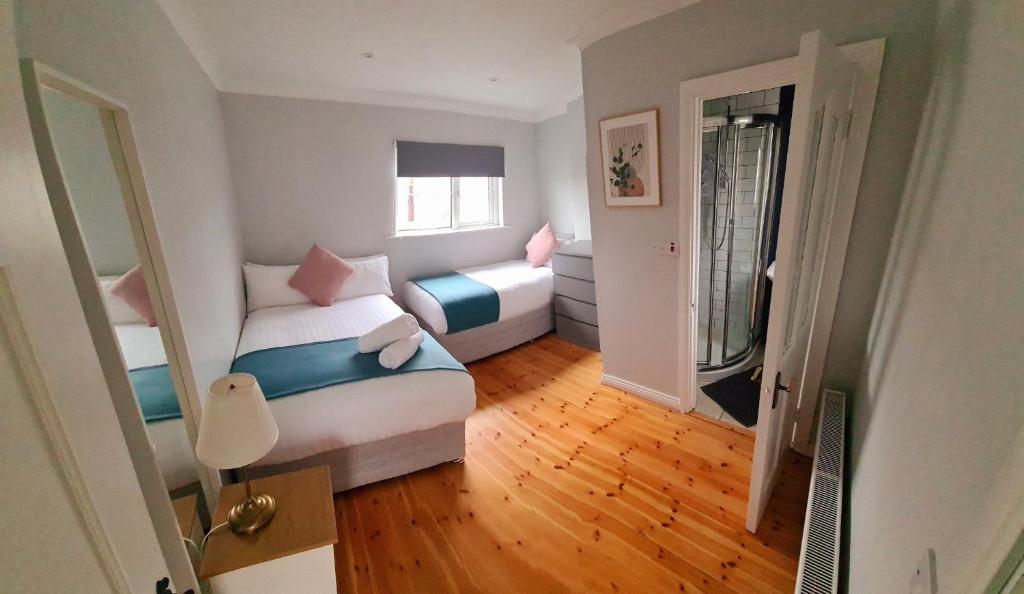 a small bedroom with two beds and a window at Stylish 3 Bedroom Galway House in Galway