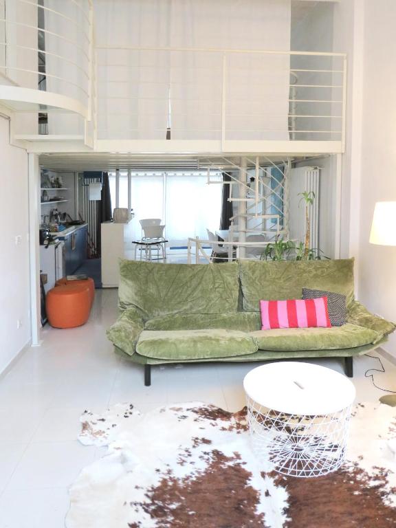 a living room with a green couch and a table at Appartamento open space in Turin
