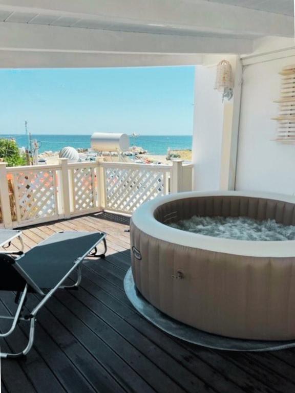 a hot tub on a deck with a view of the ocean at Thalassia Avra Stegna Beach in Archangelos