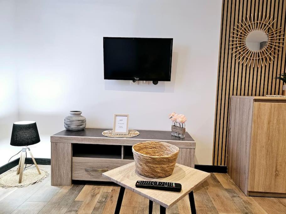ein Wohnzimmer mit einem TV und einem Tisch mit einem Korb in der Unterkunft appartement cosy à seloncourt in Seloncourt