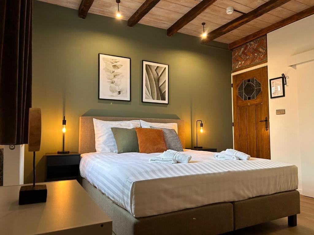 a bedroom with a large bed with two towels on it at Hotel De Hoogmolen in Oudsbergen 