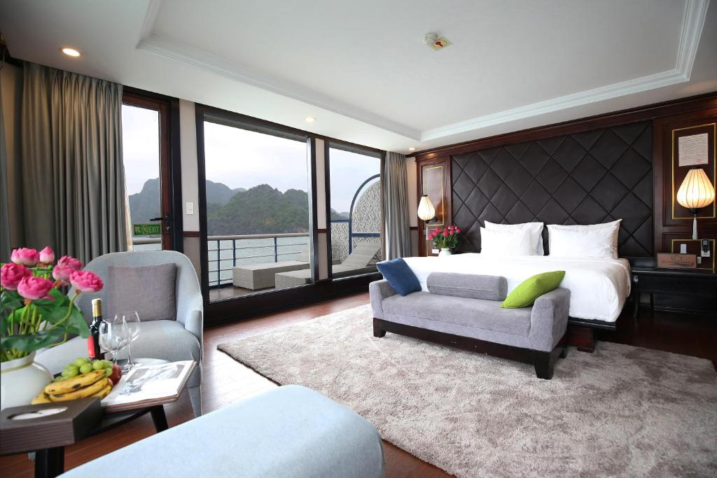 a bedroom with a bed and a couch and a chair at Lotus Luxury Cruise in Ha Long