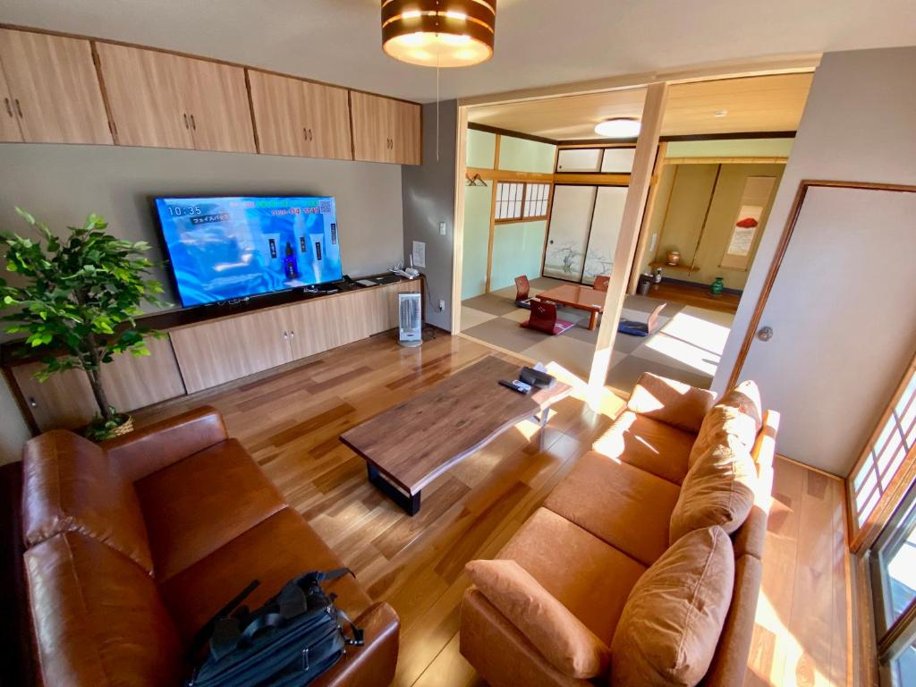 sala de estar con sofá y TV de pantalla plana en 貸切御宿　憩（Ikoi）/ Nikko Kinugawa Area en Imaichi