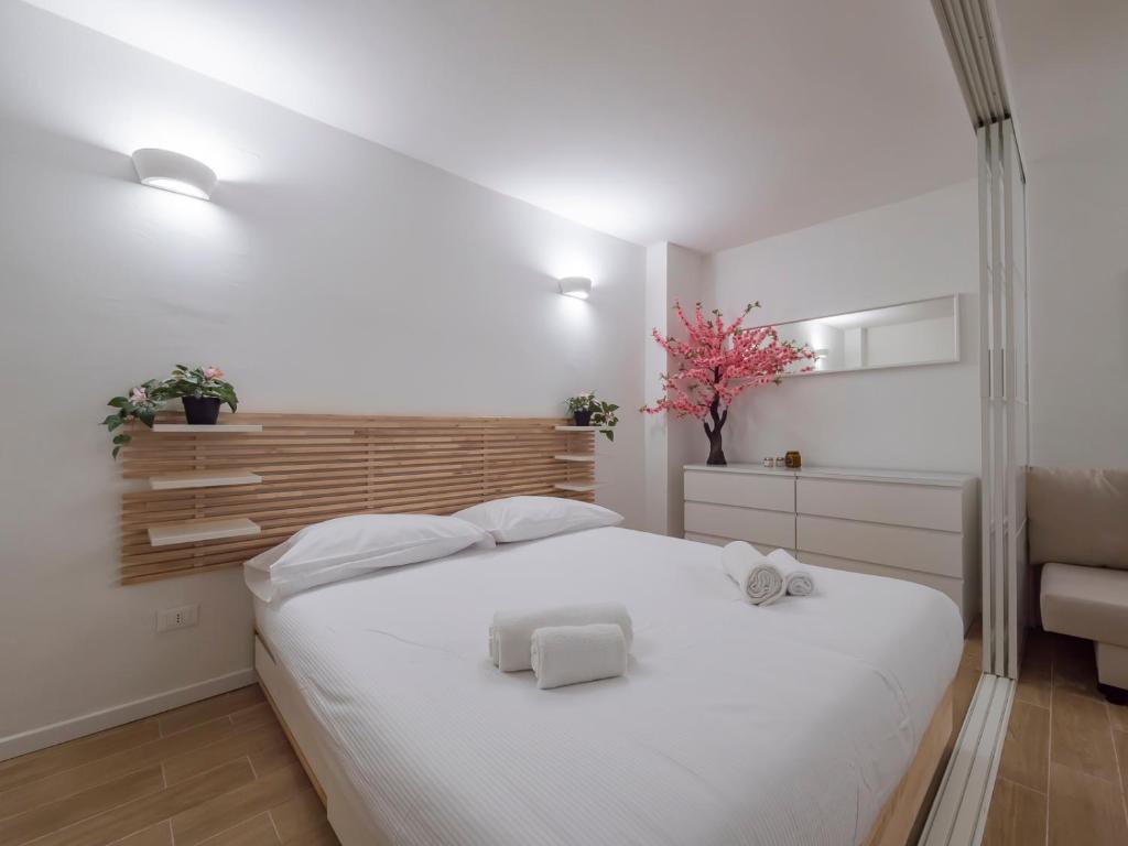 a bedroom with a white bed with two towels on it at I Host Apartment - Forlanini 1 in Milan