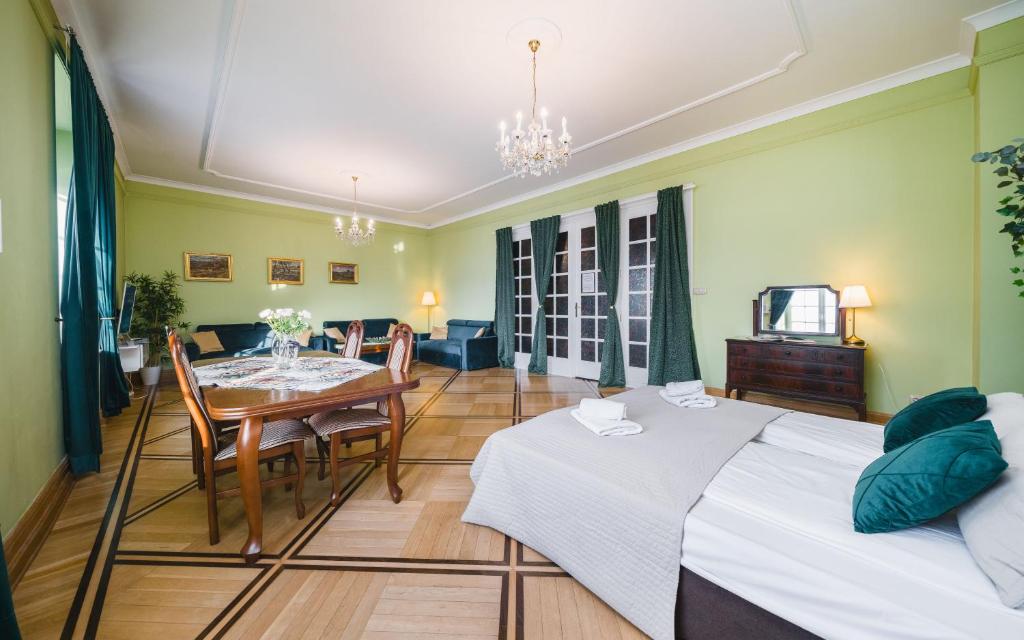 クラクフにあるアパルタメンティ w Pałacu Pod Baranamiのベッド2台、テーブル、ダイニングルームが備わります。