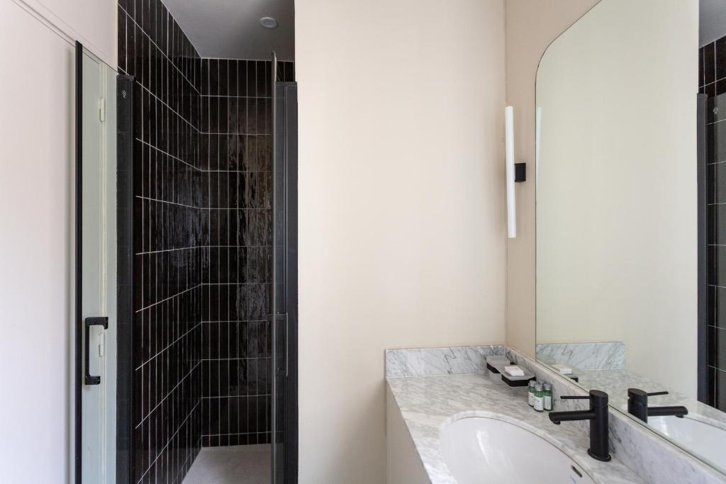 a bathroom with a sink and a shower at The Carla Suite Eiffel Tower View in Paris
