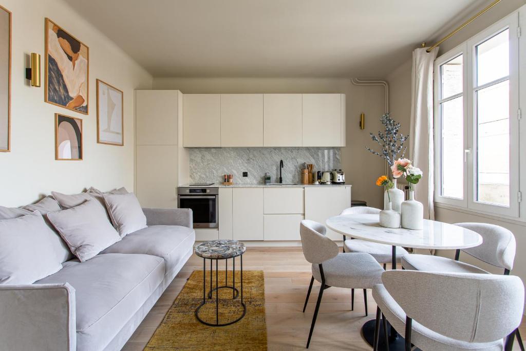 a living room with a white couch and a table at The Carla Suite Eiffel Tower View in Paris