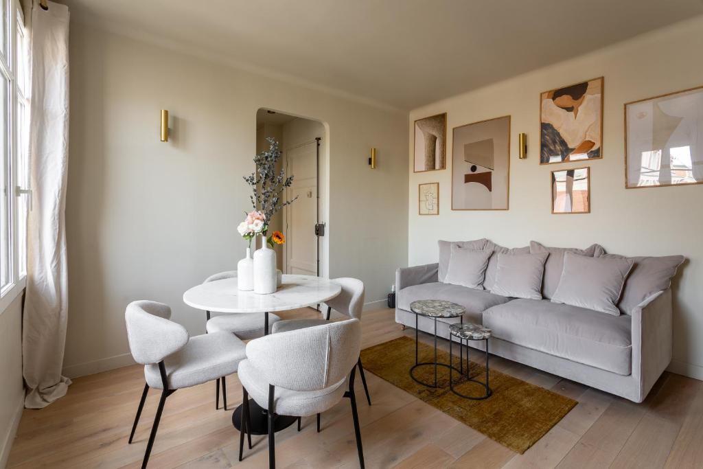 a living room with a couch and a table at The Carla Suite Eiffel Tower View in Paris