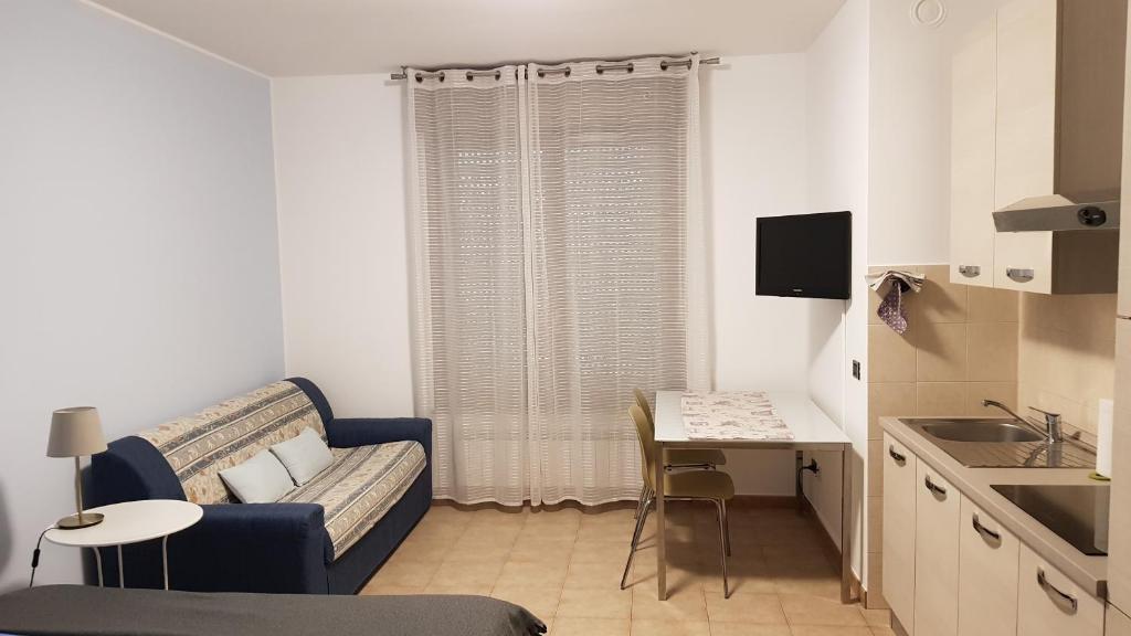 uma pequena sala de estar com um sofá e uma mesa em Mihousing-GM1, Ampio Monolocale nelle vicinanze di Milano e Monza em Carugate
