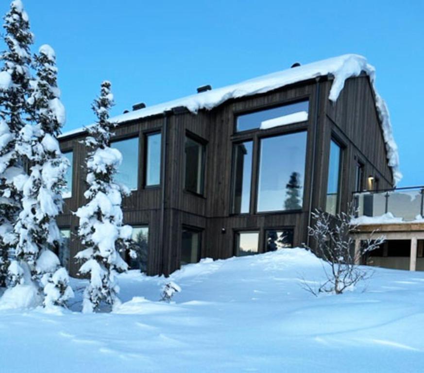 een houten huis in de sneeuw met sneeuw bedekte bomen bij Charming cottage in Vemdalen near skiing in Vemdalen