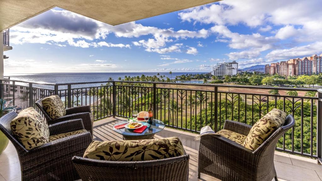 balcón con sillas, mesa y vistas al océano en Ko Olina Beach Villas B706, en Kapolei