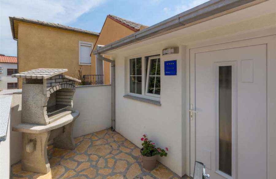 a small house with a door and a porch at Holiday home in Crikvenica 39225 in Crikvenica