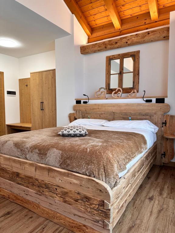 1 dormitorio con 1 cama grande de madera en una habitación en C’era una volta un Re… en Calalzo