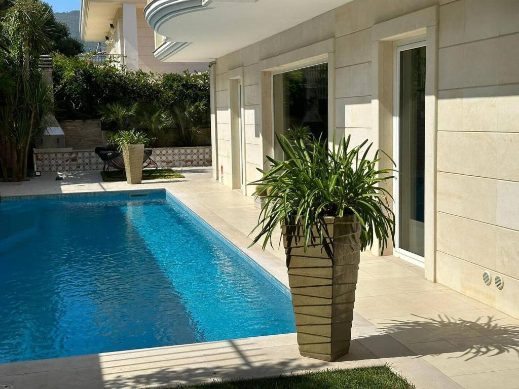 - une piscine avec une plante en pot à côté d'une maison dans l'établissement Home suite Home, à Avellino