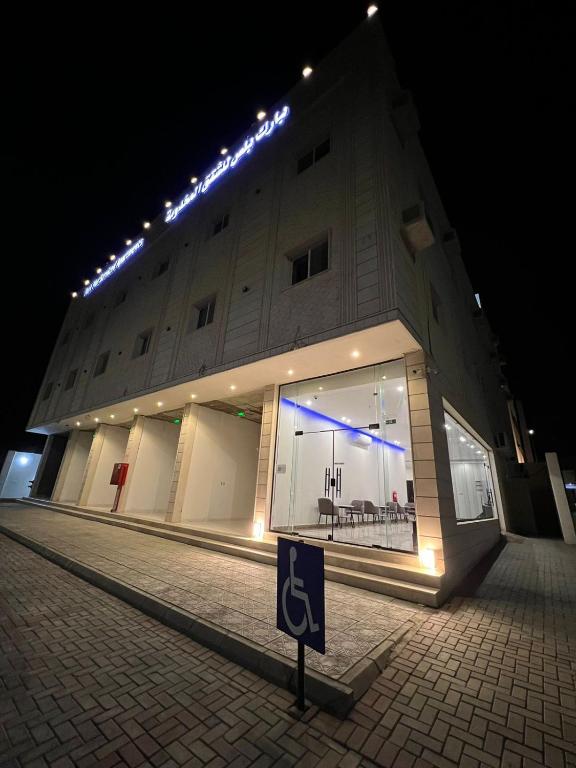 a building with a sign in front of it at night at بارك بلس للشقق المخدومة in AR Rummanah