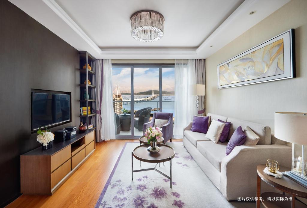 a living room with a couch and a tv at Savills Residence Daxin Shenzhen Bay in Shenzhen