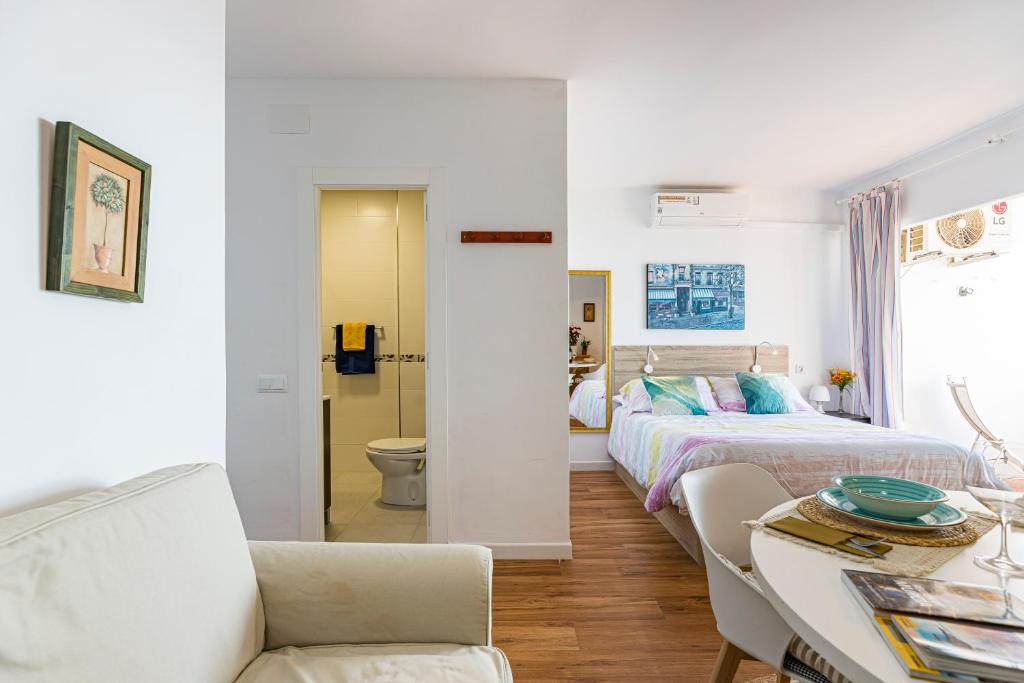 Un dormitorio con una cama y una mesa y sillas. en The Manga Beach Sea view Studio, Sandy beach & Crystal clear water, 5G Wifi & Airco, en La Manga del Mar Menor