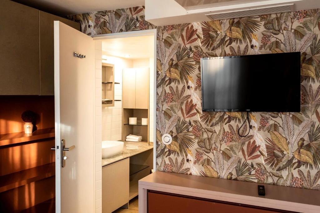 a bathroom with a flat screen tv on a wall at MULTIRESIDENCE L&#39;ELYSEE Paris in Paris