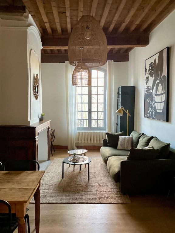 un salon avec un canapé et une table dans l'établissement La bohème place aux herbes, à Uzès