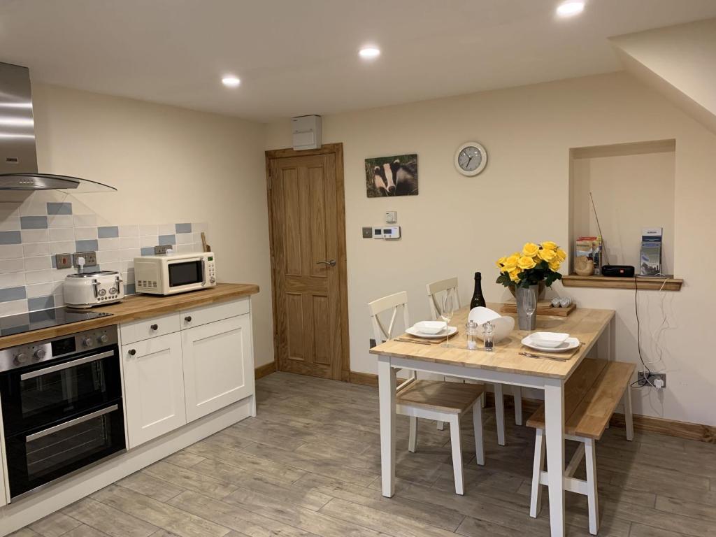 a kitchen with a table with chairs and a microwave at Locheil Apartment in Boat of Garten