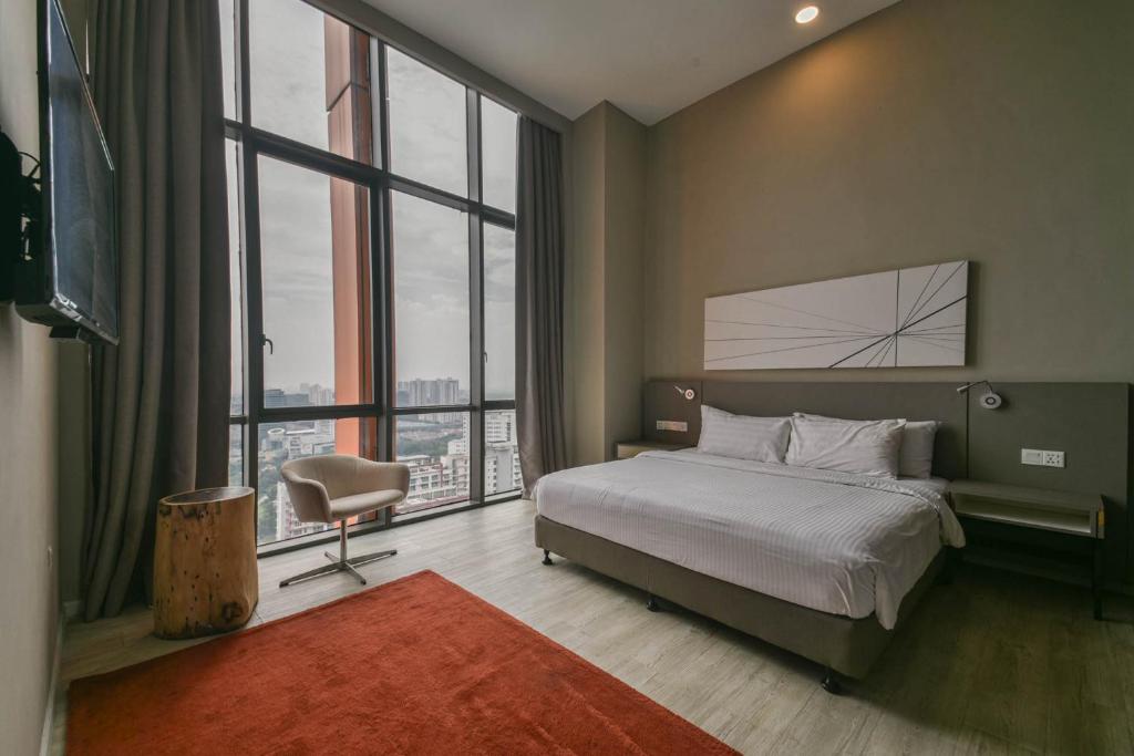a bedroom with a bed and a large window at PlayStaytion Damansara by RBNB in Damansara Perdana