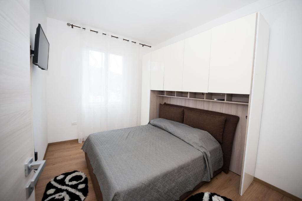 a bedroom with a bed in a white room at Stanza doppia con bagno e cucina in comune Genova in Genoa