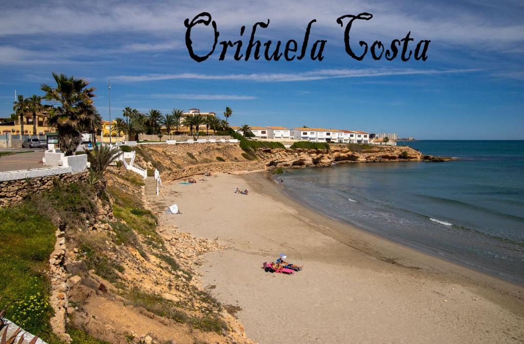 une plage avec des gens sur le sable et l'océan dans l'établissement Bungalow à Orihuela Costa en Espagne, à Orihuela