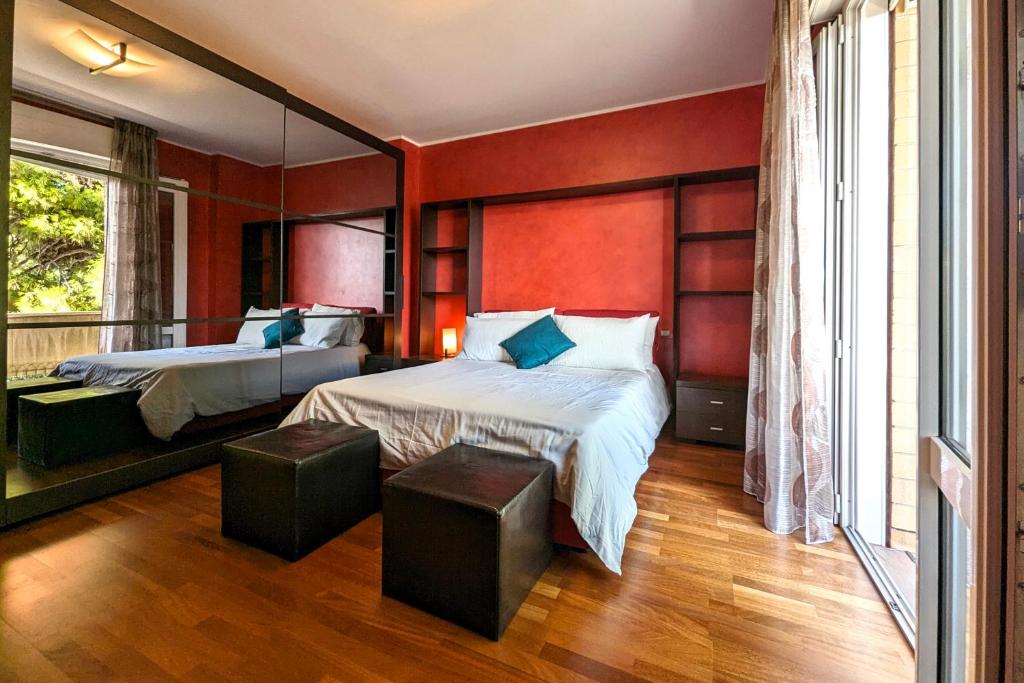a bedroom with two beds and a large window at 200mt dal mare by WeHostYou Parcheggio Wifi Clima Balcone Bbq in Fermo