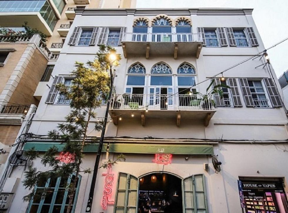 - un bâtiment blanc avec un balcon dans une rue dans l'établissement Hotel Lost, à Beyrouth