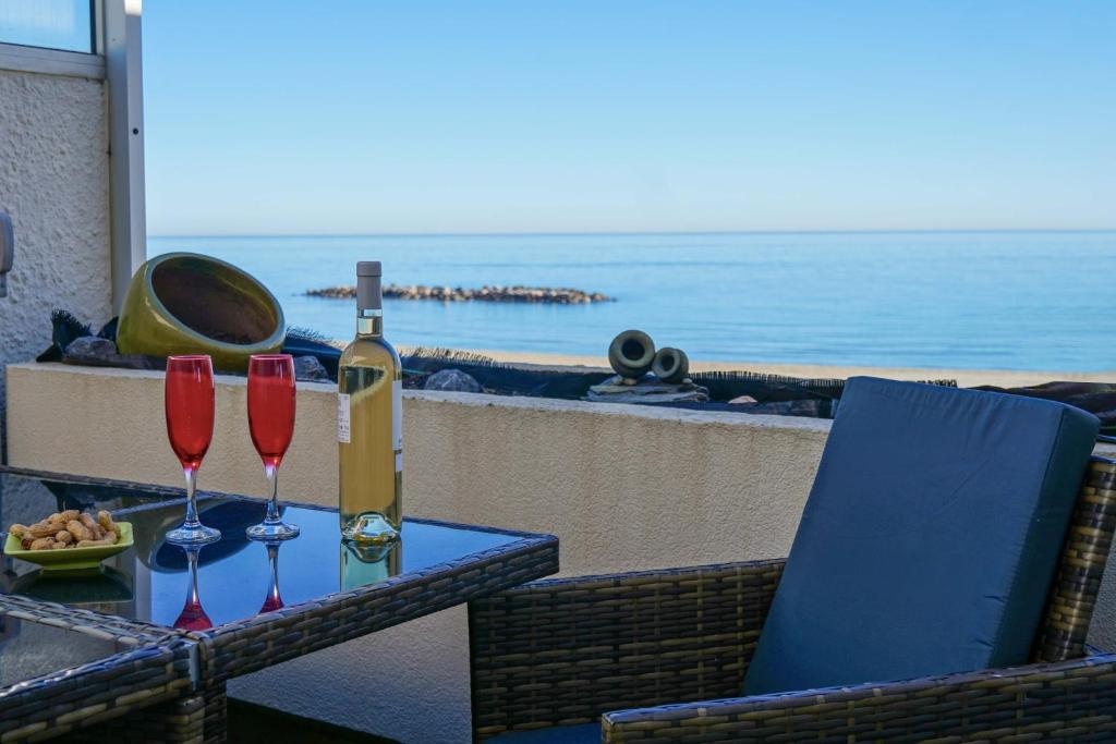 - une table avec 2 verres et une bouteille de vin dans l'établissement Chez Jo, au Barcarès
