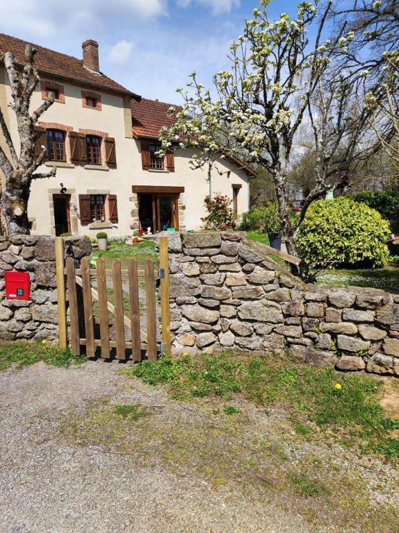 une clôture en pierre devant une maison dans l'établissement Gite du Dolmen classé 3 épis, à Blessac